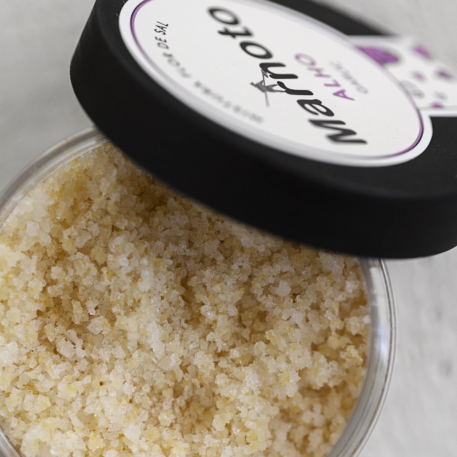 Close-up of a container of salt with a brand label on a white background