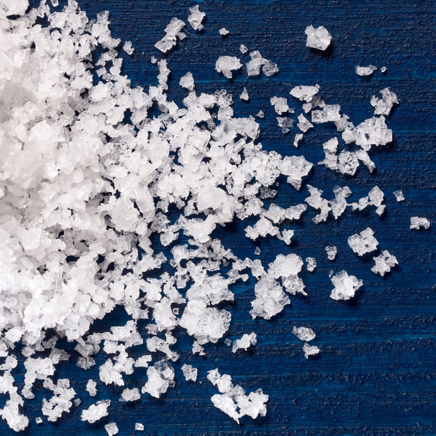 Close-up of white salt crystals on a blue surface