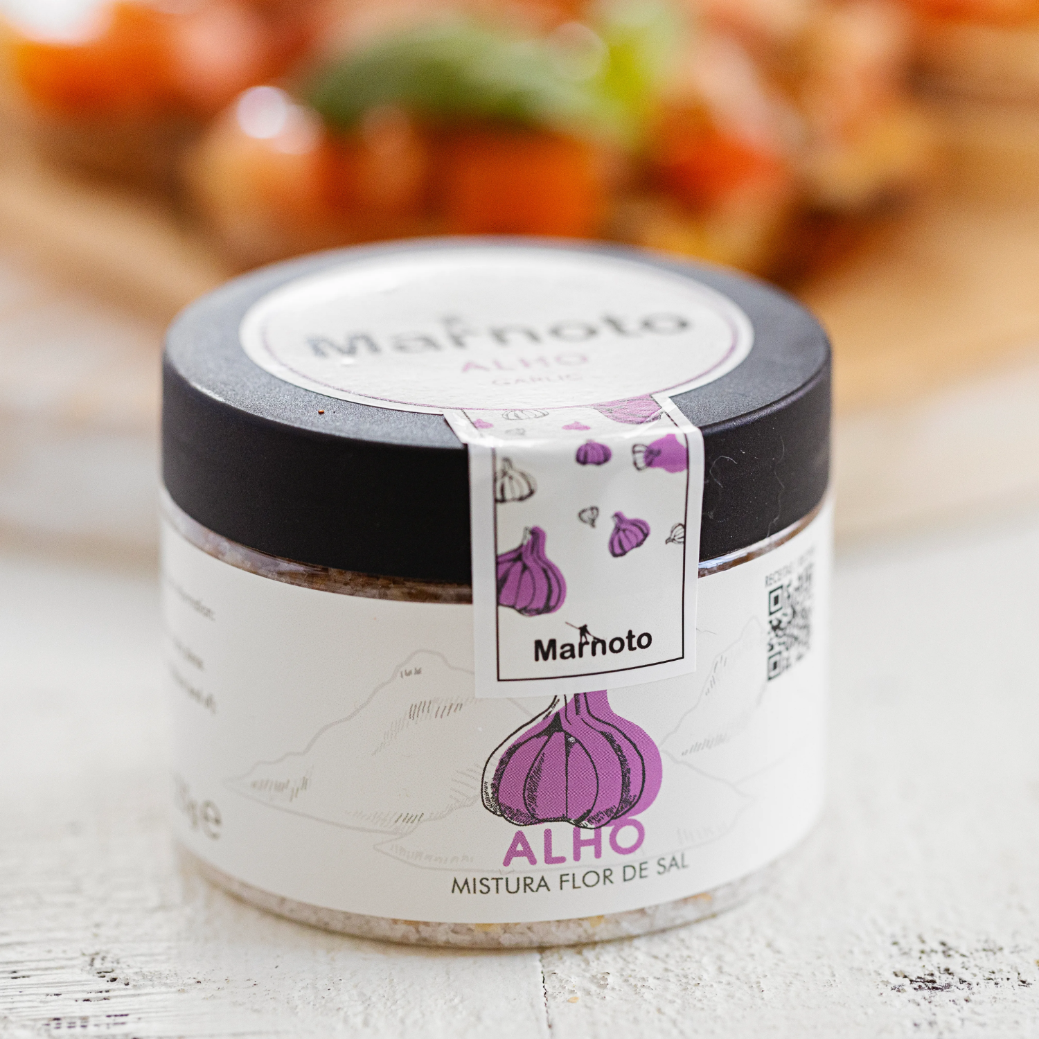 Jar of Marnoto Alho seasoning on a wooden surface with blurred background