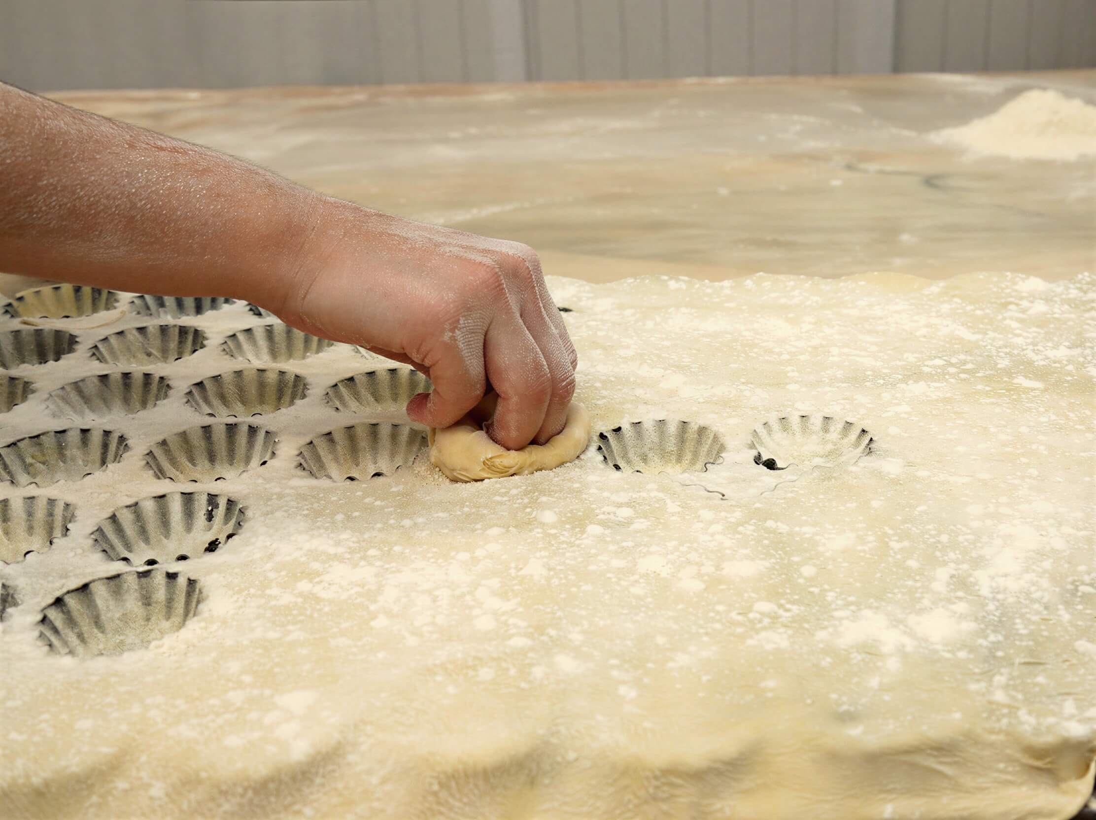 Worker making Queijadas De Vila Franca Do Campo Do Morgado Portuguese Custard Cakes