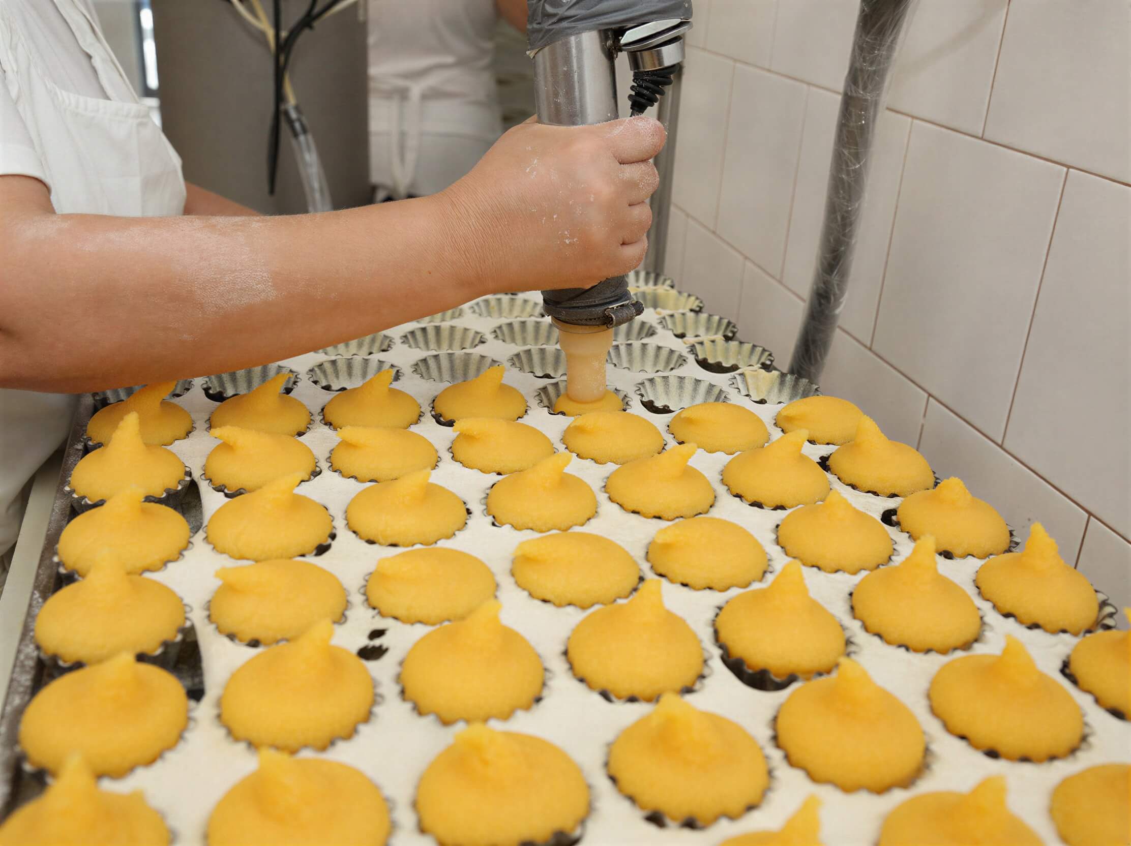 Worker making Queijadas De Vila Franca Do Campo Do Morgado Portuguese Custard Cakes