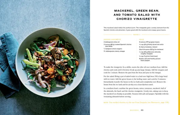 Salad with mackerel, green beans, and tomatoes on a blue surface with text on the side.
