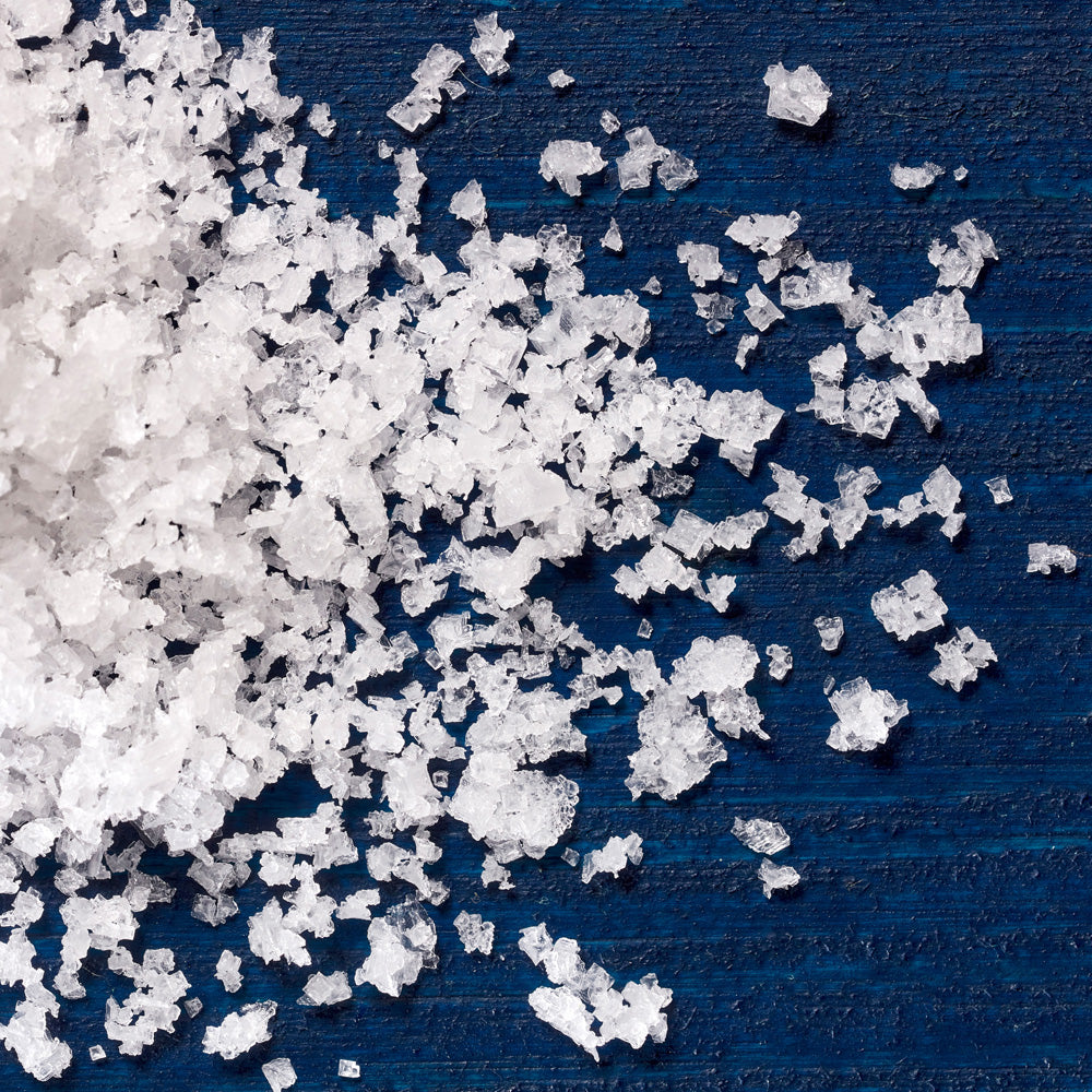 Close-up of white salt crystals on a blue surface