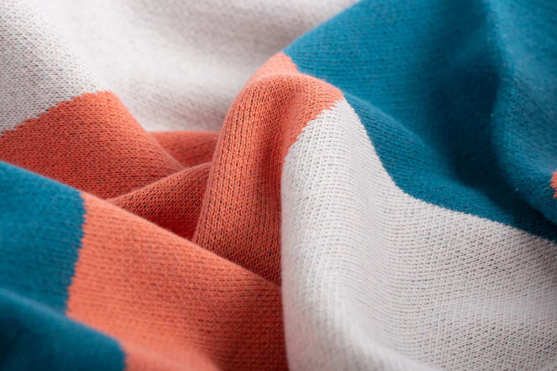 Close-up of fabric with blue, orange, and white colors.