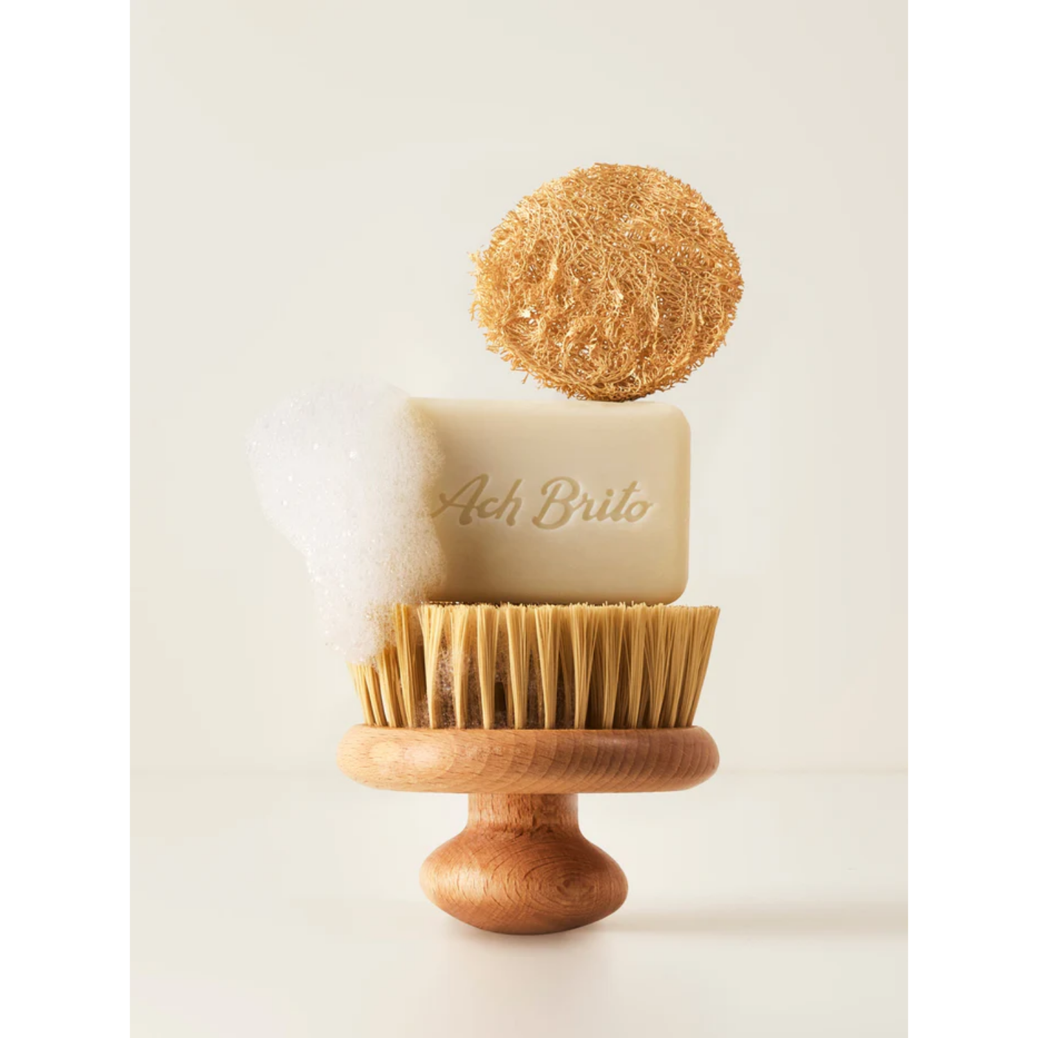 Bar of soap with a wooden stand and natural scrubber on a light background