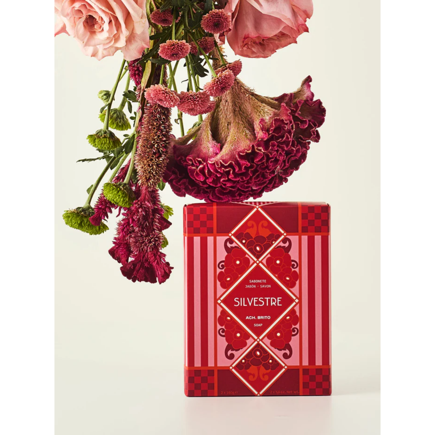 Red floral box with pink and red flowers on a light background