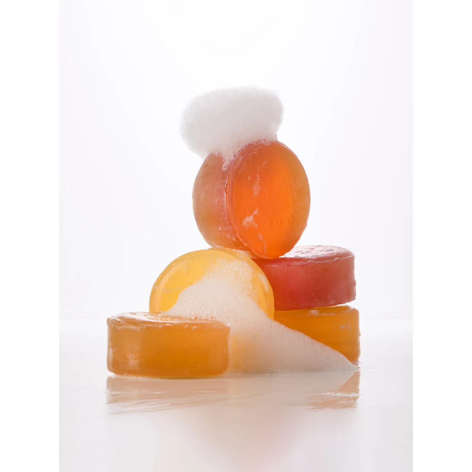 Stack of colorful jelly-like soap on a white background