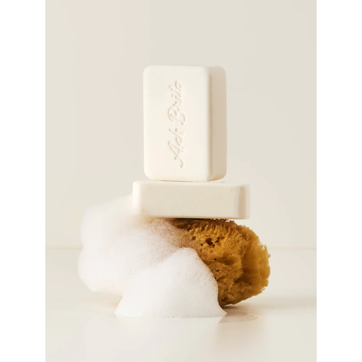 Bar of soap with a brown sponge on a white background